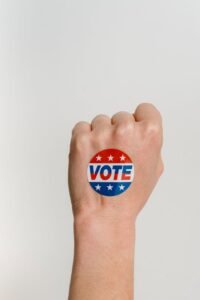 person s fist with vote sticker