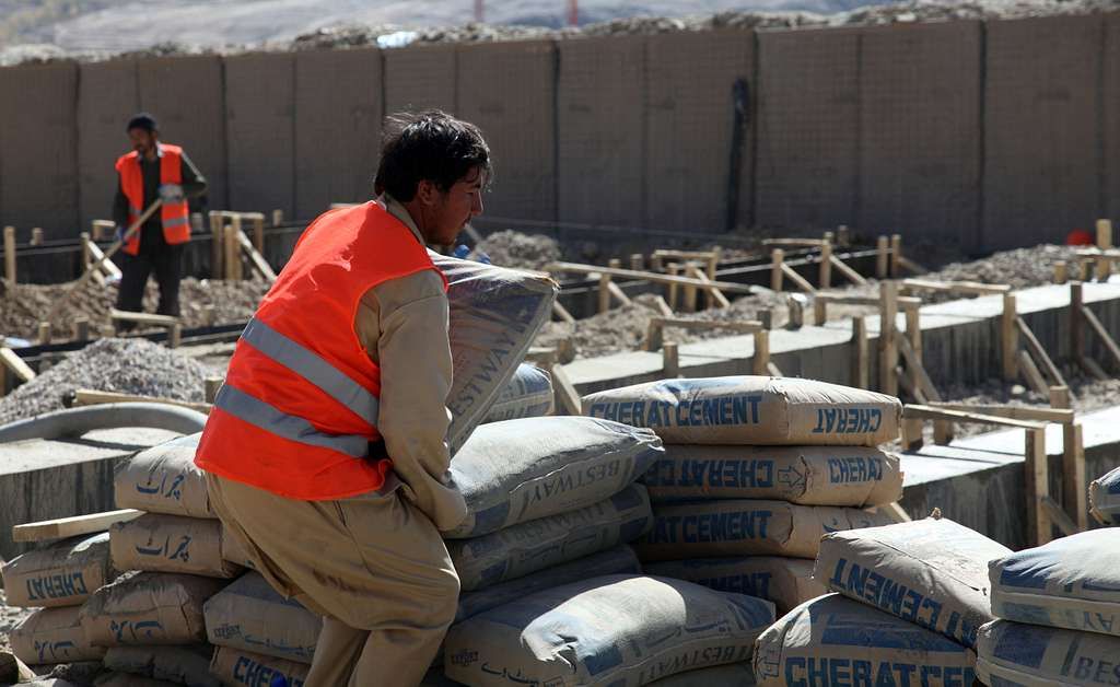 an afghan construction worker carries bags of concrete 87be92 1024281294449737265495147648